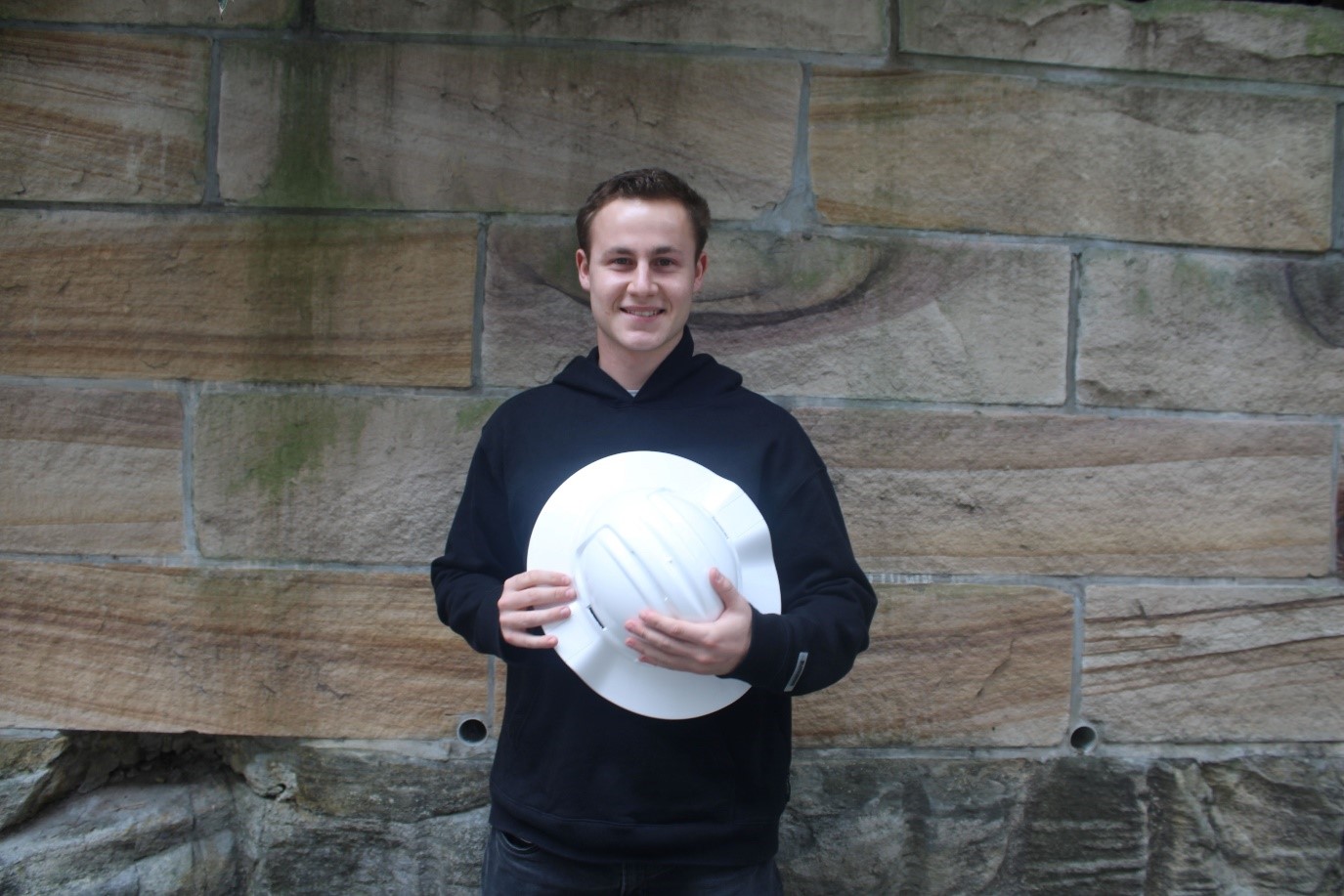 A person holding a white hatDescription automatically generated
